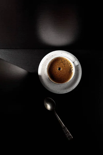 ブラックテーブルの上にブラックコーヒーとホワイトカップ コピースペース付きのトップビュー — ストック写真