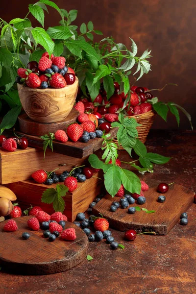 用叶子对新鲜浆果进行分类 覆盆子 蓝莓和甜樱桃放在老式桌子上 — 图库照片