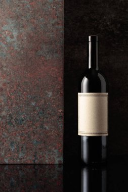 Paslı kahverengi arka planda eski boş etiketli bir şişe kırmızı şarap. Metnin için alanı olan ön görünüm.