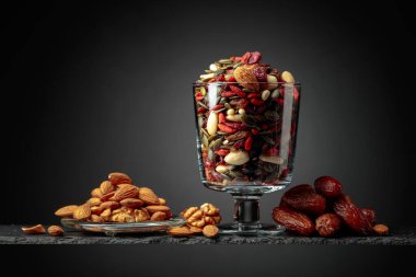 Siyah arka planda hurmalar, kuru meyveler, fındıklar ve tohumlar. Boşluğu kopyala.