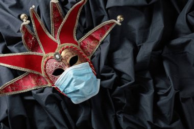 Maskeyi koruyan karnaval maskesi. Virüsün temasının kavramsal görüntüsü. Boşluğu kopyala.