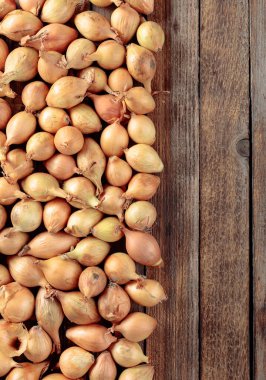 Eski ahşap bir masada soğan. Üst görünüm, alanı kopyala.