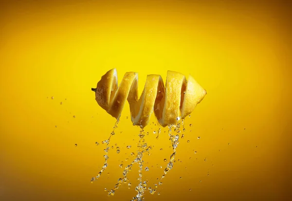 新鮮なレモンと黄色の背景にスプラッシュ — ストック写真