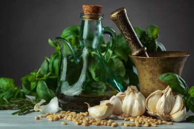 Zeytin yağı, sarımsak, yeşil fesleğen ve çam fıstığı ile eski bakır havan. .