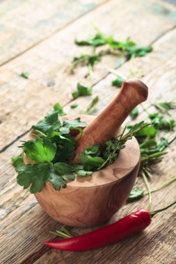 Biberiye, kişniş, kekik ve maydanozlu ahşap havan..