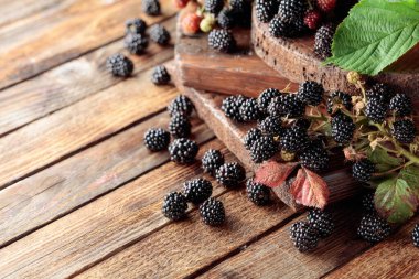 Eski ahşap bir masada taze böğürtlen.