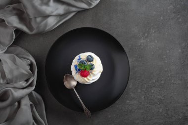 Ahududu, yaban mersini ve naneli küçük Pavlova tatlısı. Üst görünüm.