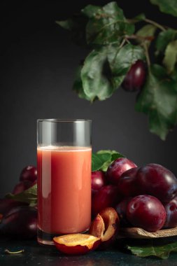 Taze mor erikli bir masada bir bardak erik suyu..