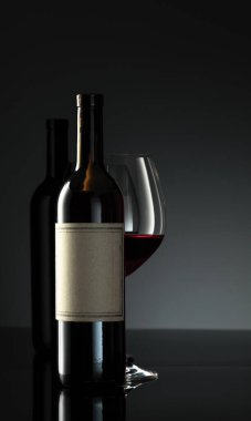 Siyah yansıtıcı arka planda bir şişe kırmızı şarap. Metnin için fotokopi alanı olan eski bir şişenin üzerinde.