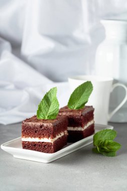 Gri bir masada naneli çikolatalı pasta..
