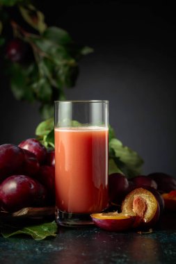 Taze mor erikli bir masada bir bardak erik suyu. Boşluğu kopyala.