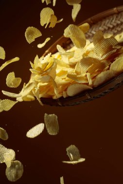 Sarı arka planda patates cipsi düşmesi. Boşluğu kopyala.