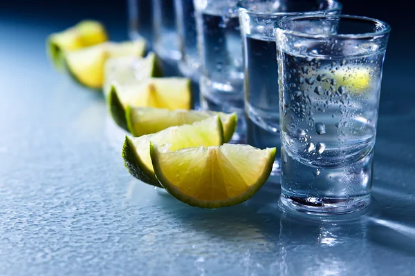 Tequila e cal na mesa de vidro — Fotografia de Stock
