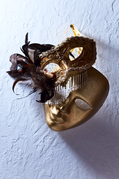 Венецианские маски на старой стене — стоковое фото