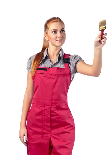 Young woman in red overalls with brush — Stock Photo, Image