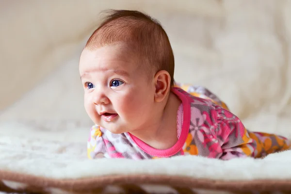 Liten flicka på beige filt — Stockfoto