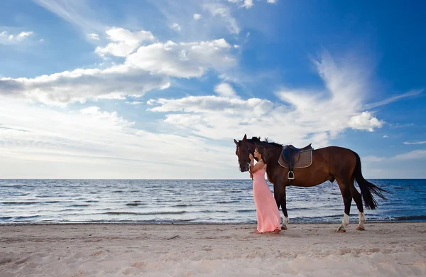 Hermosa chica con caballo en la costa — Foto de Stock