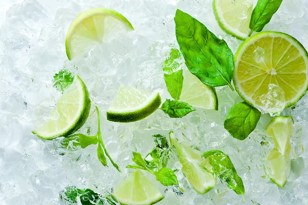 Lime pieces and leaves of mint with ice — Stock Photo, Image