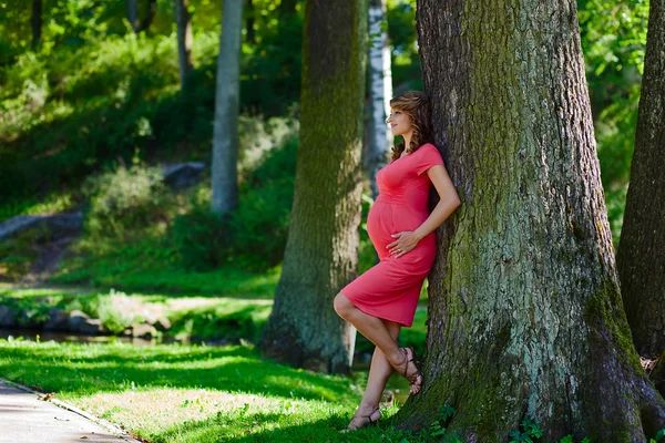 Unga gravid kvinna i park — Stockfoto