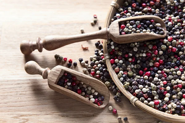 Peppercorns on wooden table — Stock Photo, Image