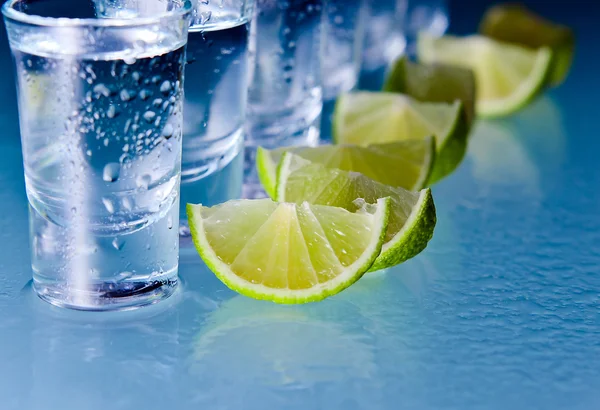 Tequila e cal na mesa de vidro — Fotografia de Stock