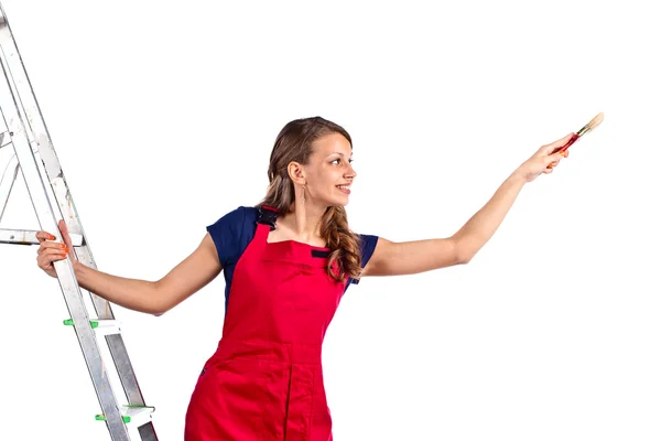 Young woman in a red jumpsuit on  ladder — Stock Photo, Image