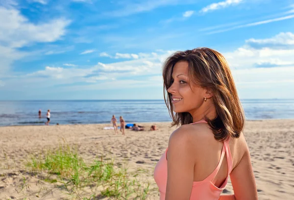 Donna in abito rosa sulla costa — Foto Stock