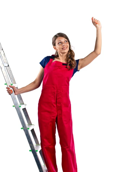 Young woman in a red jumpsuit on  ladder — Stock Photo, Image