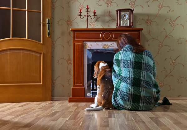 woman with  dog near a fireplace