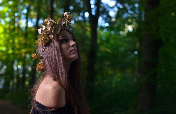 The young beautiful woman in dark forest