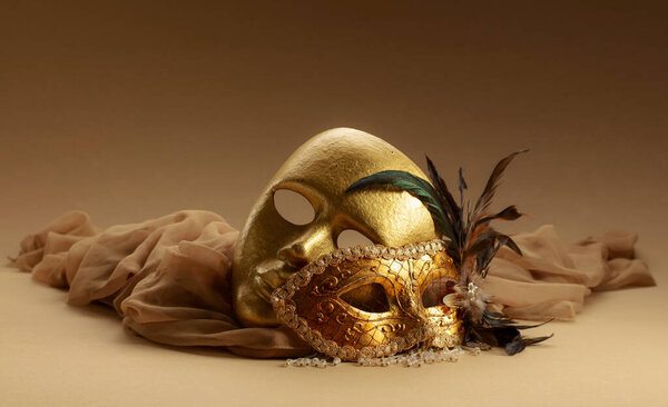 Золотые венецианские карнавальные маски. Винтажные маски на бежевом фоне. Копирование пространства.