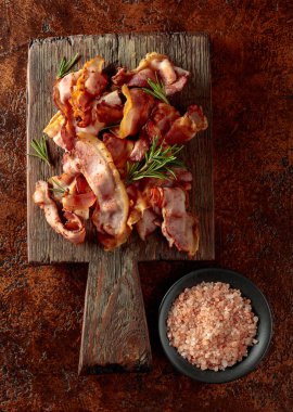 Kızarmış pastırma, biberiye ve esmer bir arka planda pembe tuz. Üst görünüm, alanı kopyala.