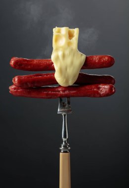 Izgara sosis ve çatal üzerinde peynir..