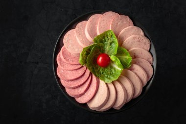Various boiled sausages on a black background. Top view.