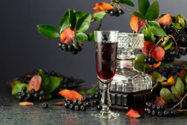 Siyah bir masada böğürtlen likörü ve taze böğürtlen..