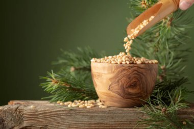 Soyulmuş çam fıstığı ve sedir dalı eski bir ahşap masada. Boşluğu kopyala.