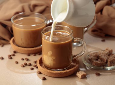 Koyu kahvenin içine krema dök. Latte hazırlanıyor..