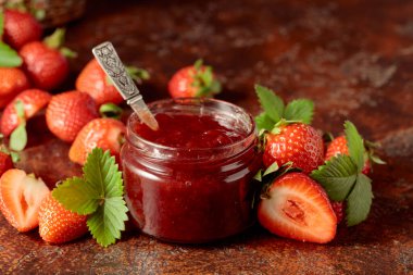 Strawberry jam and fresh berries with leaves. 