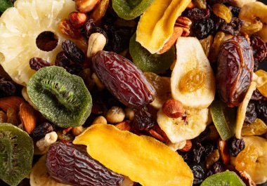 Dried tropical fruits with various nuts and raisins, macro shot.