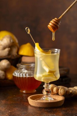 Kahverengi arka planda limonlu ve ballı zencefil çayı.