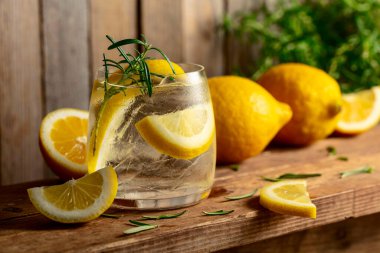 Eski ahşap bir masada buzlu, biberiyeli ve limonlu yaz ferahlatıcı bir içecek. Taze, sağlıklı, soğuk limon suyu. Buzlu ve limonlu su.