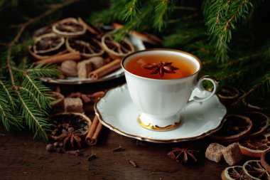Baharatlı Noel çayı ve eski ahşap bir masada kurutulmuş narenciye dilimleri..