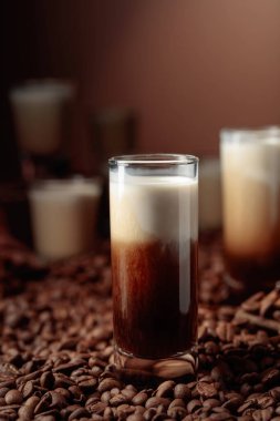 Beyaz Rus kokteyli. Votka, kahve likörü ve krema. Kahve çekirdekleri, tarçın ve anason masaya saçılmış..