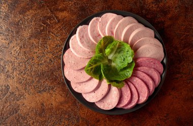 Siyah bir tabakta çeşitli haşlanmış sosisler. Boşluğu kopyala.