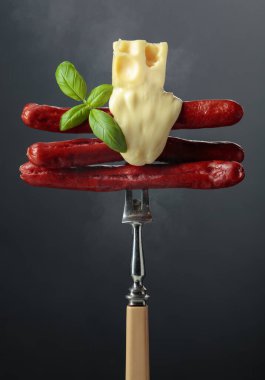 Erimiş peynir ve fesleğenli ızgara ince sosis..