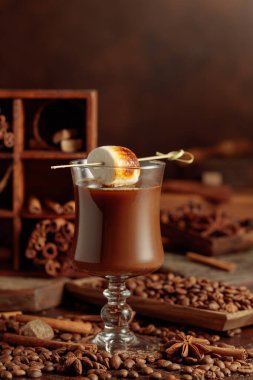 Krema ve kahve kokteyli, kızarmış marşmelovla süslenmiş. Karışık malzeme ve baharatlarla dolu bir masada kahve içeceğiz..