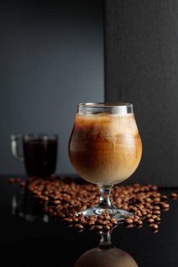 Krema ve buzlu kahve kokteyli, siyah yansıtıcı arka planda. Boşluğu kopyala.