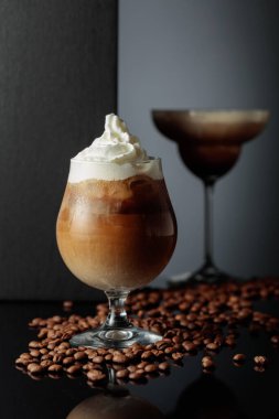 Krema ve buzlu kahve kokteyli, siyah yansıtıcı arka planda. Boşluğu kopyala.