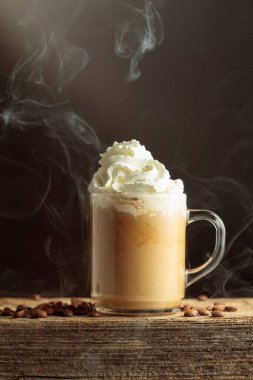 Krem şantili cam bardakta kahve. Eski ahşap bir masada kahve. Boşluğu kopyala.