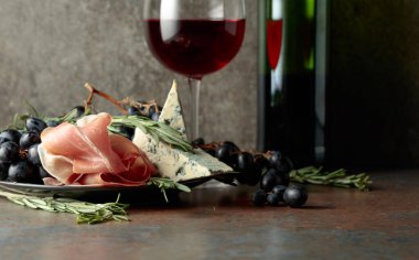 Üzümlü kırmızı şarap, biberiye, prosciutto ve klasik arka planda mavi peynir.. 